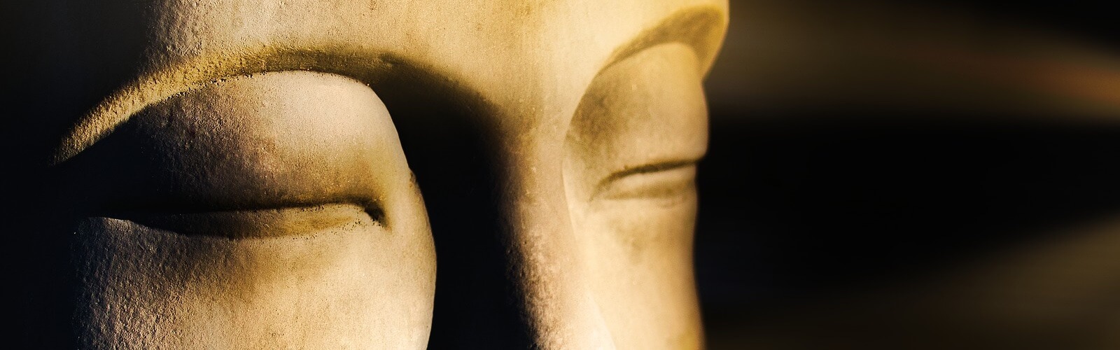 Closed eyes of a Buddha statue in meditation - Free Group Meditation Sessions in Phuket.