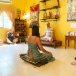 Tobi Warzinek gives a meditation class at the Phuket Meditation Center. Six people sit together in meditation.