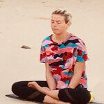 Portrait of Rachel Horner practicing meditation on a beach.
