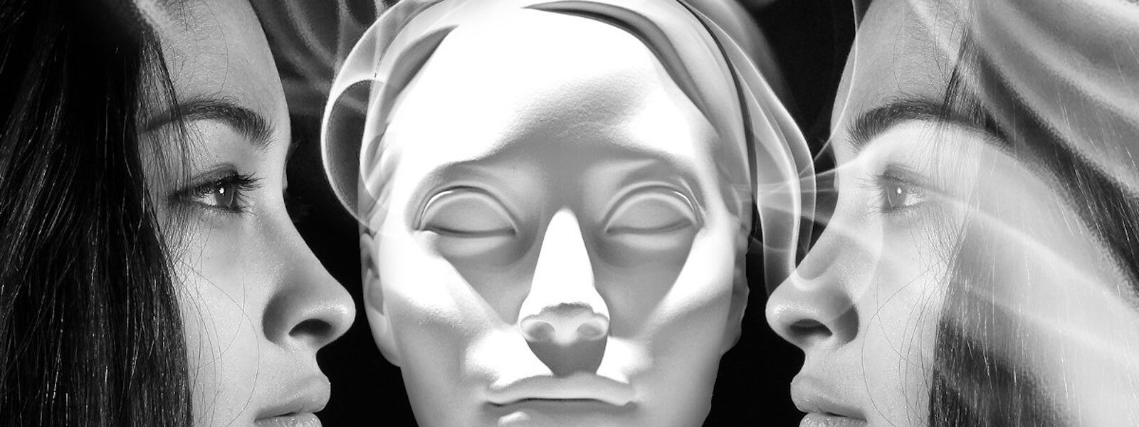 A mirrored woman is looking into her own face. A white mask is between the faces.