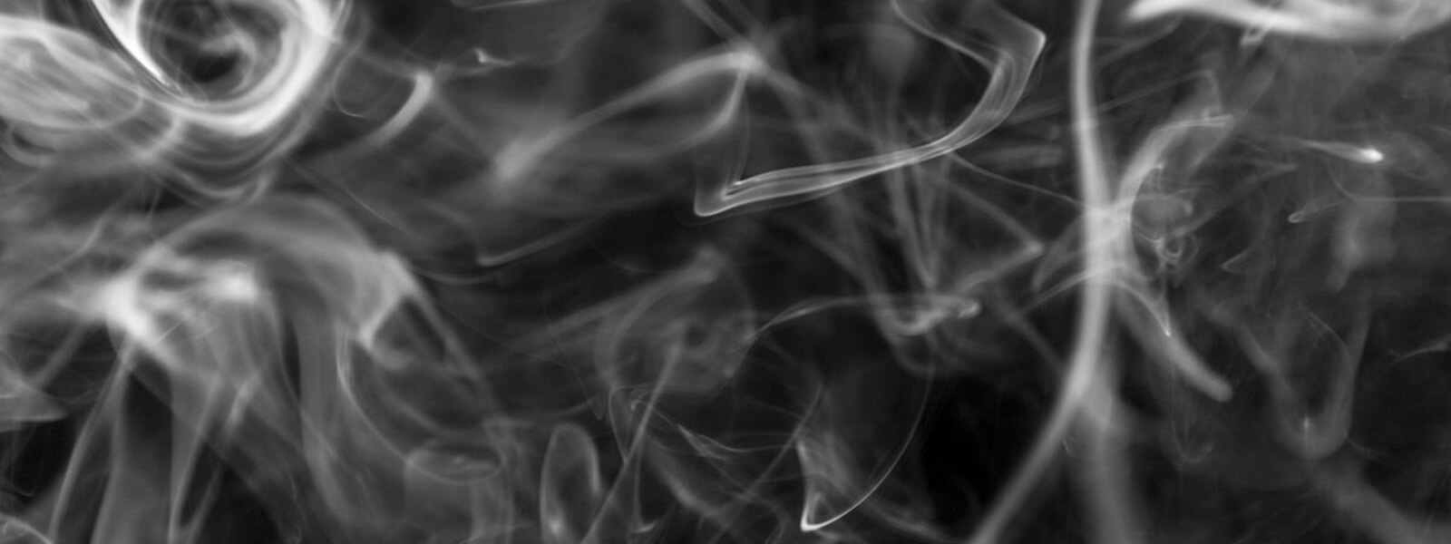 Lines of smoke floating through black space.