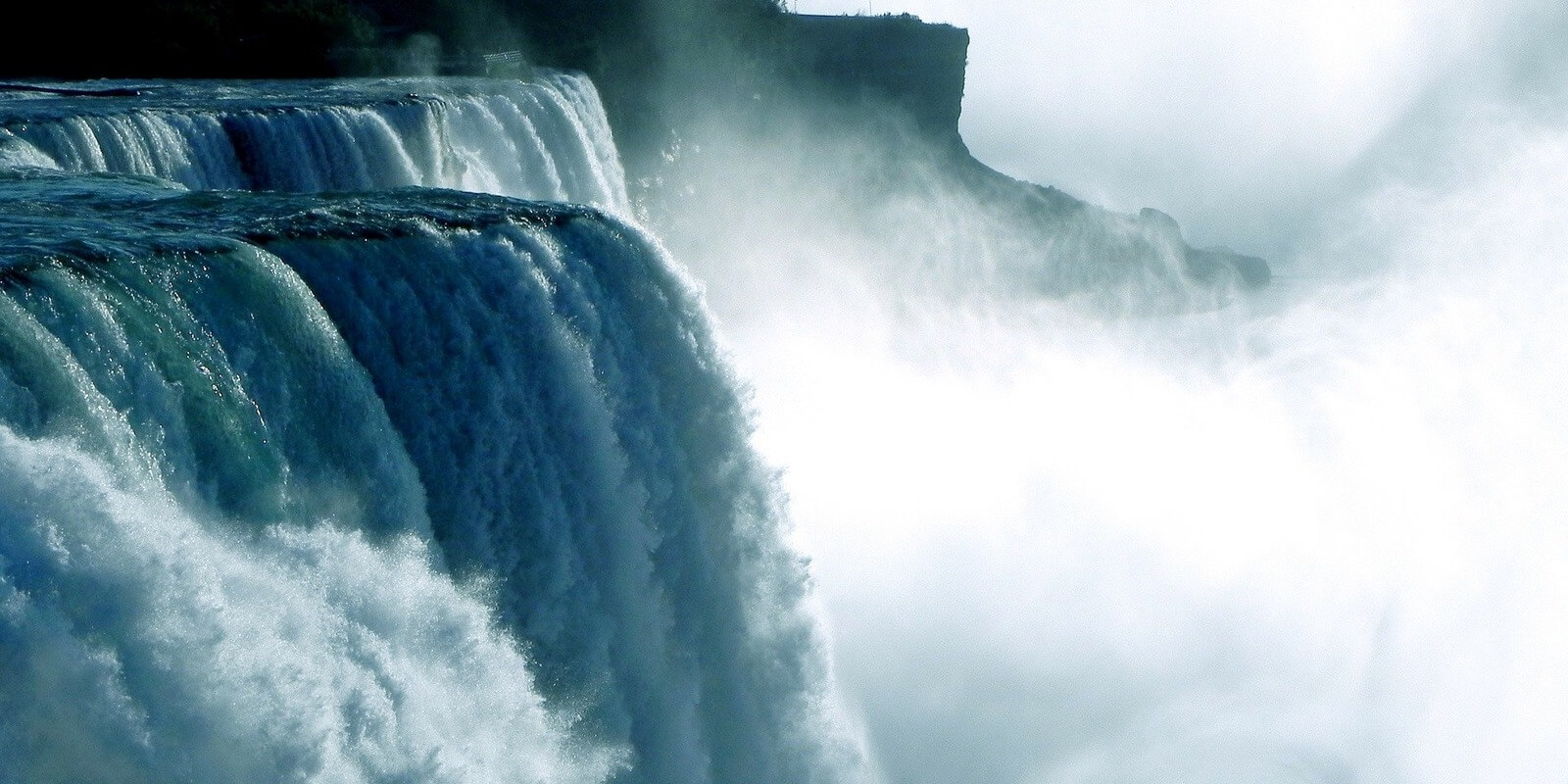 A massive waterfall falling into a large cloud of mist.
