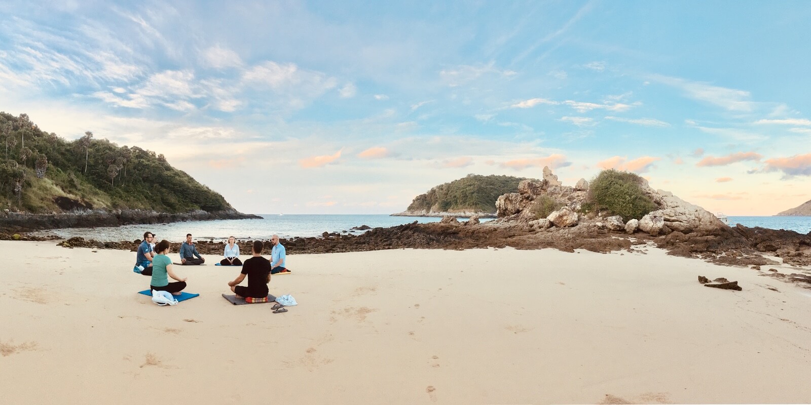 Seven meditators sit on Yanui beach in Phuket together and practice mindfulness.