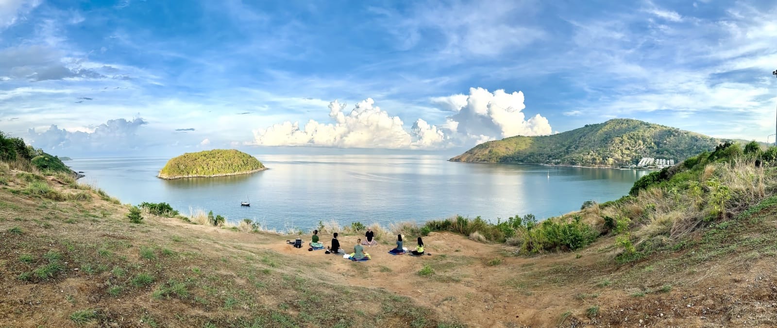Participants meditating during a morning excursion on a Phuket meditation retreat overlooking the ocean in Thailand