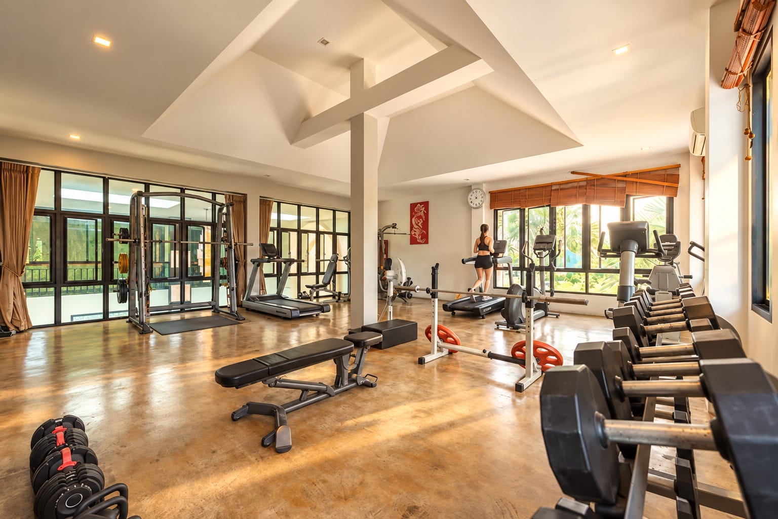 Cozy Gym interior of Coco Retreat Resort in Phuket with barbells and training equipment